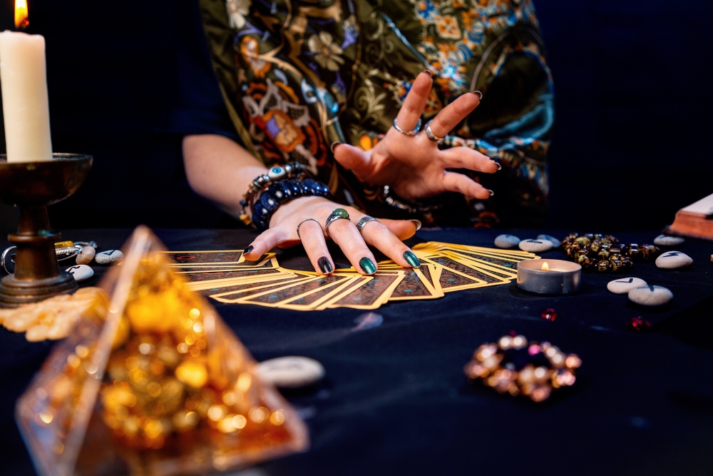 The witch spreads out her tarot cards on the table. Hands close-up. The concept of divination and astrology