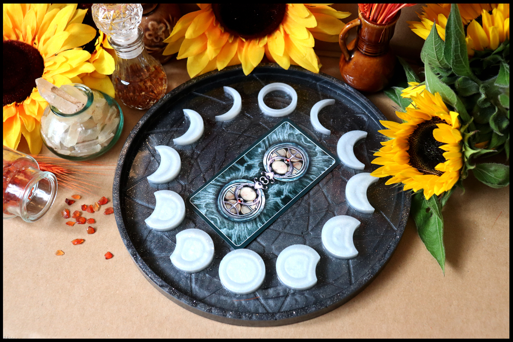  A dark plate with moon phases and a tarot card in the center.