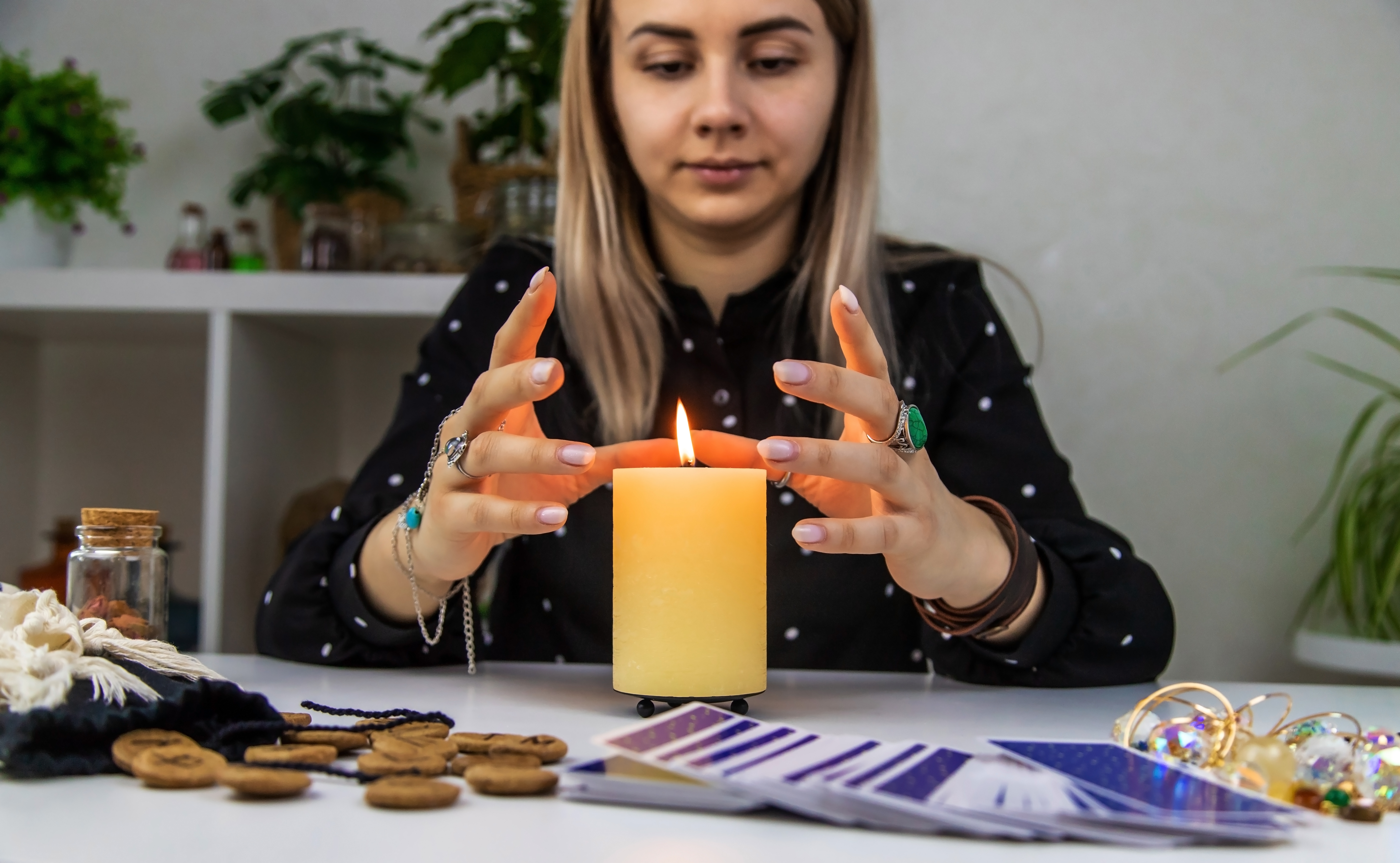 A person with their hands surrounding a lit candle.