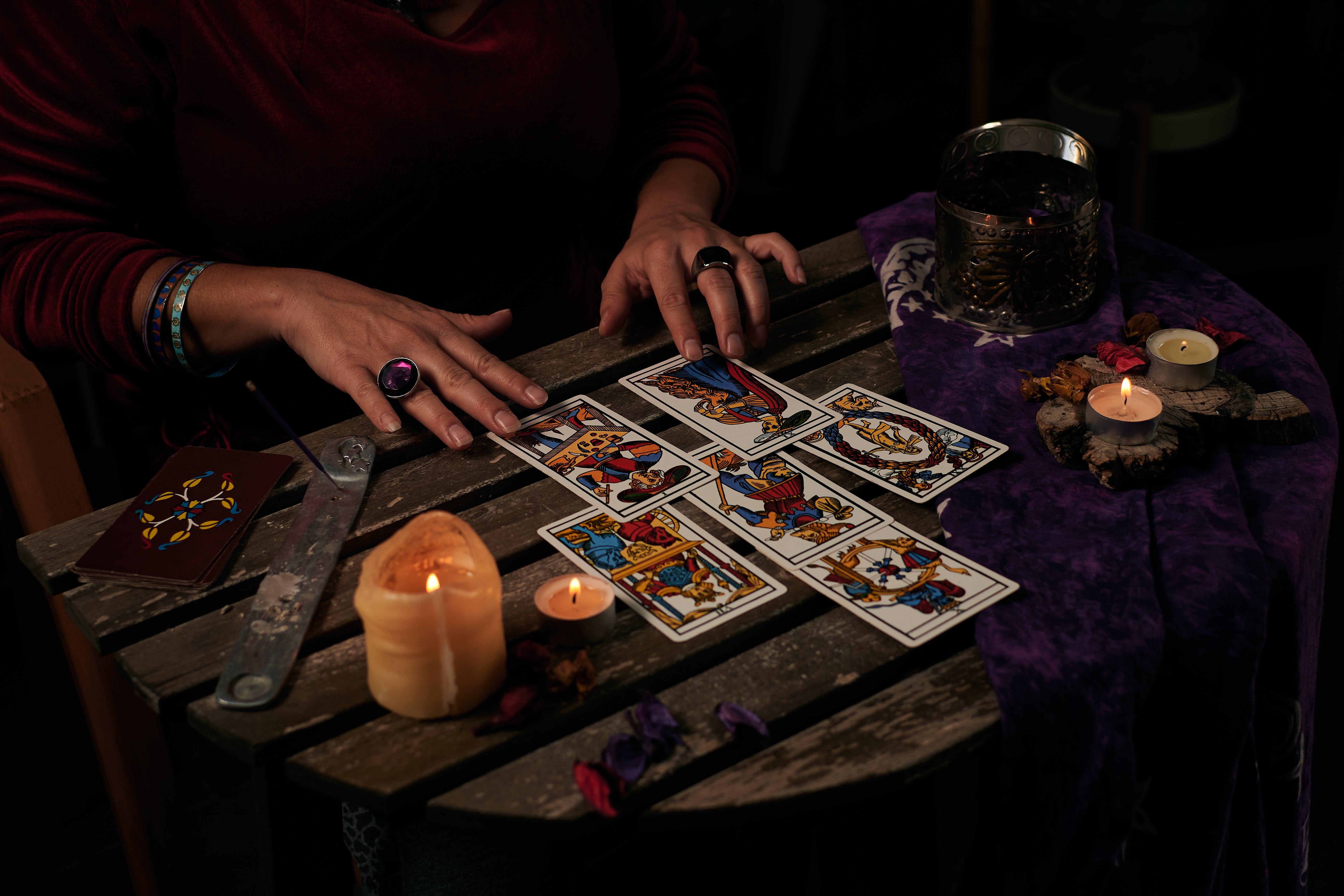 A table with a candle and six face up tarot cards