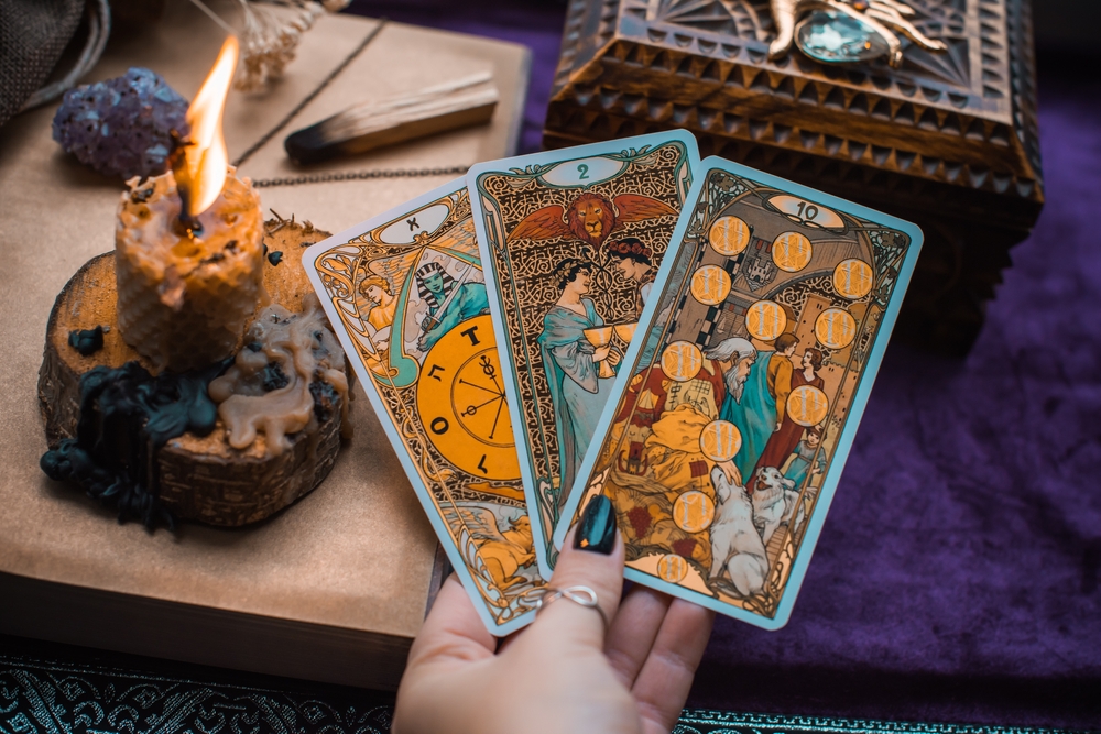 Tarot card reading magic for attracting love, rituals and fate prediction on a table.